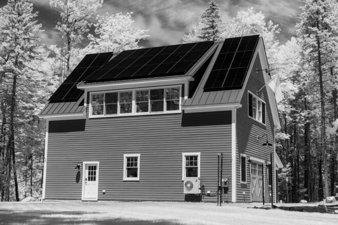 Dvigubo stiklo saulės moduliai, sumontuoti ant pastato stogo, demonstruojantys atsparumą ir ilgą tarnavimo laiką.